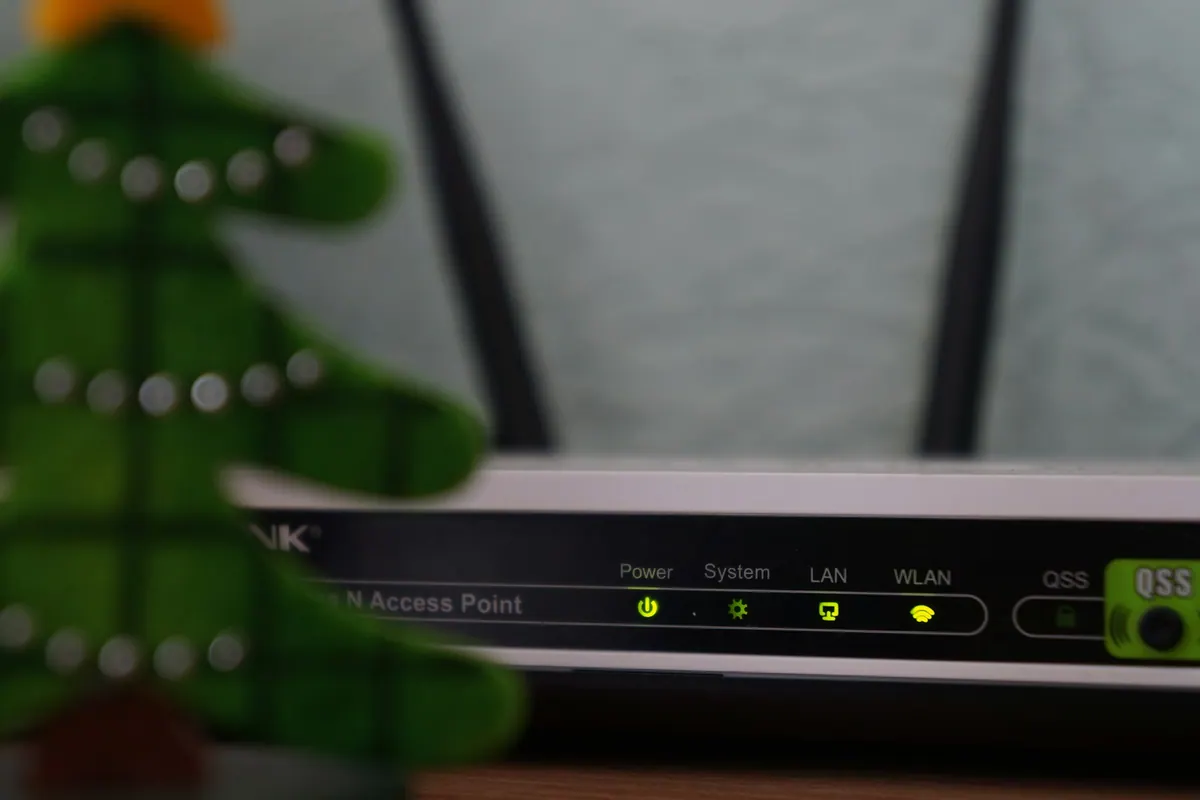 A home router with indicator lights beside its cables